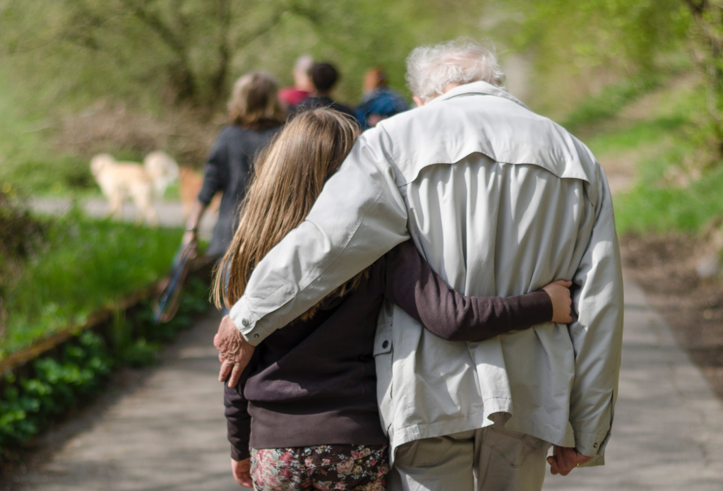 A photo of an old man and a young girl hugging as they go on a Grief Walk